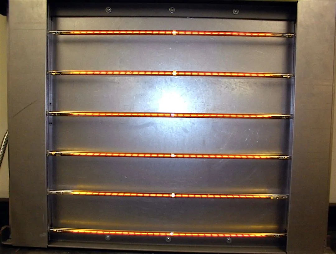 Industrial infrared heating panel and lamp layout Six illuminated infrared lamps mounted across a metal reflector panel
